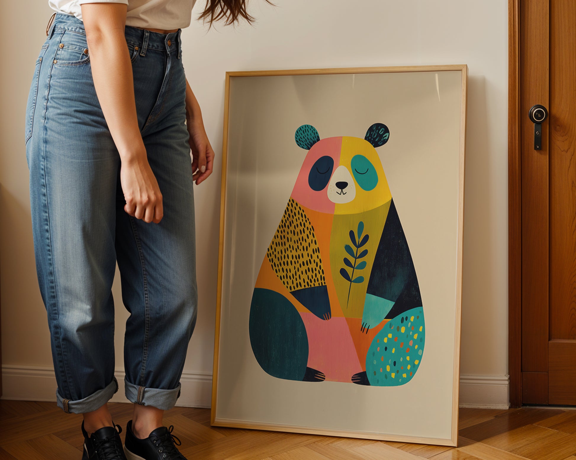 Person standing next to a colorful abstract bear painting on a wall.