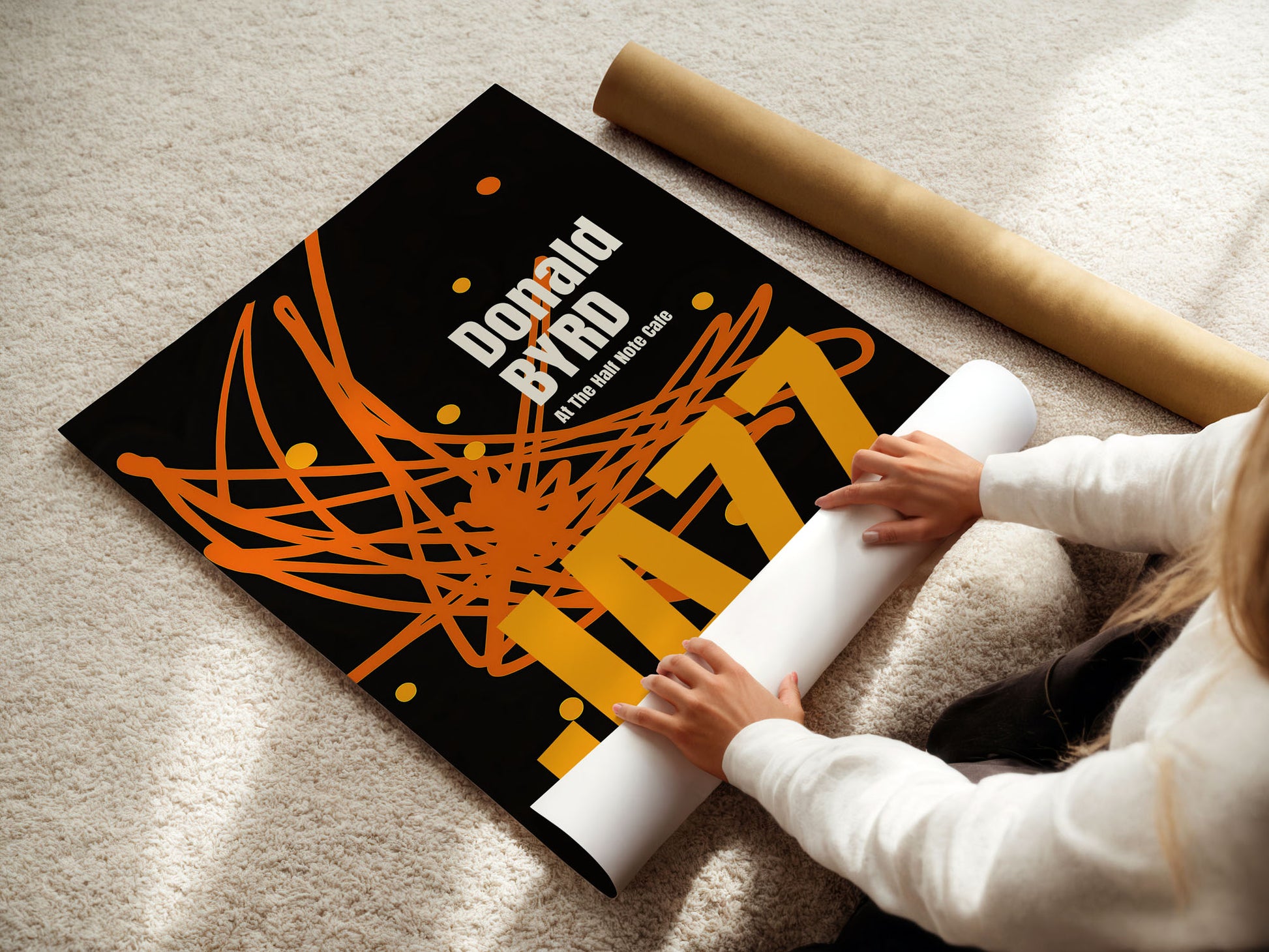 young woman with a poster with 'Donald Byrd' design on a carpeted floor