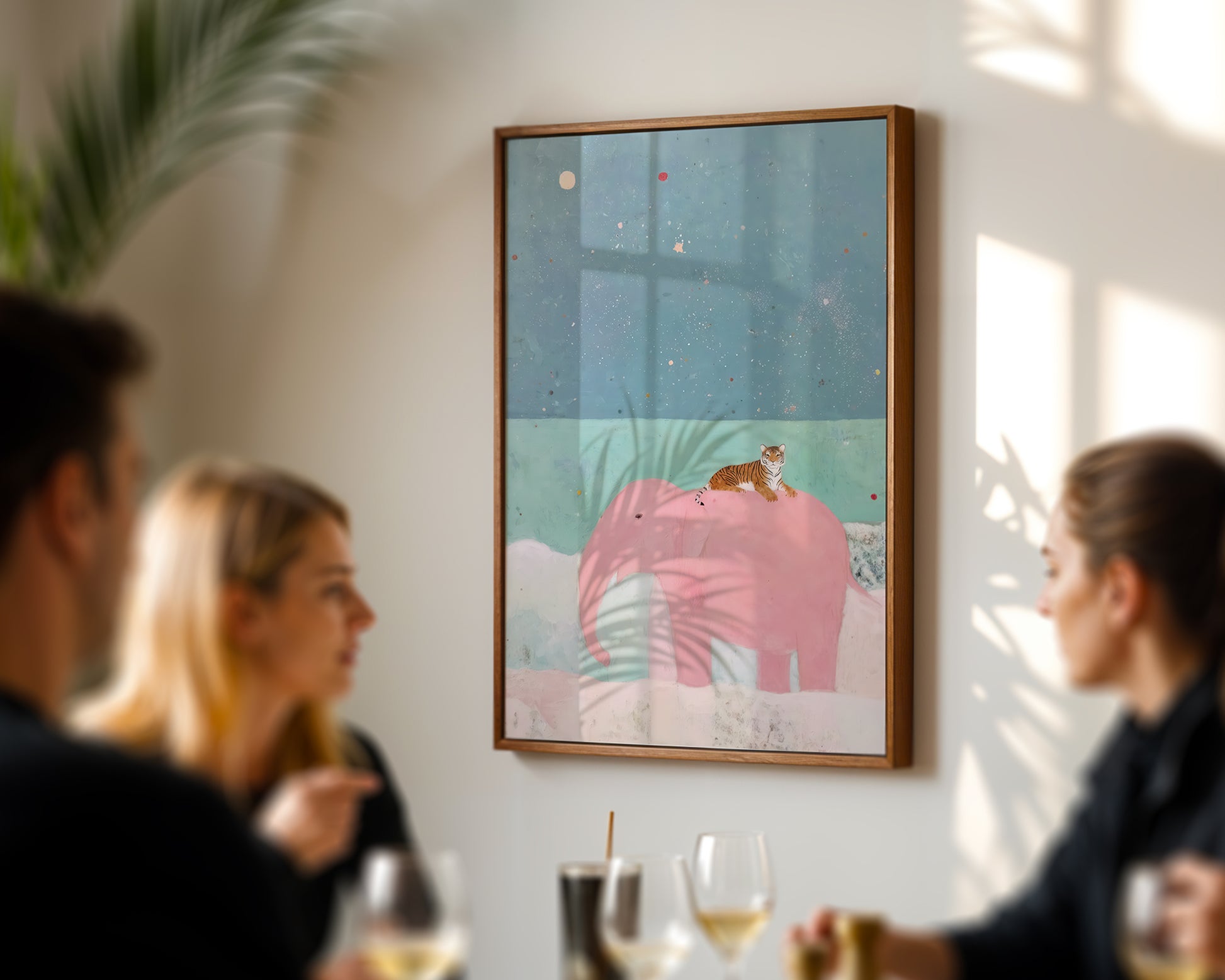 Framed artwork on a wall with people sitting at a table below it