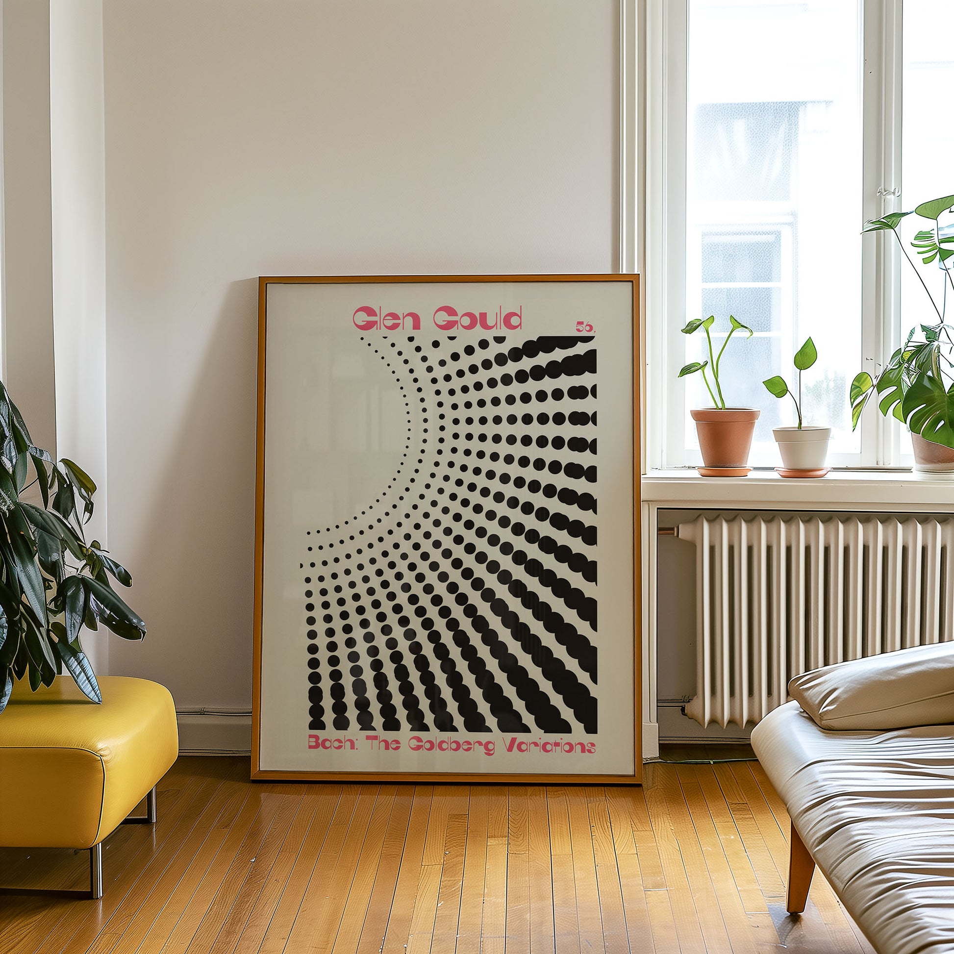 Framed abstract art piece on a wall in a living room with plants and furniture.