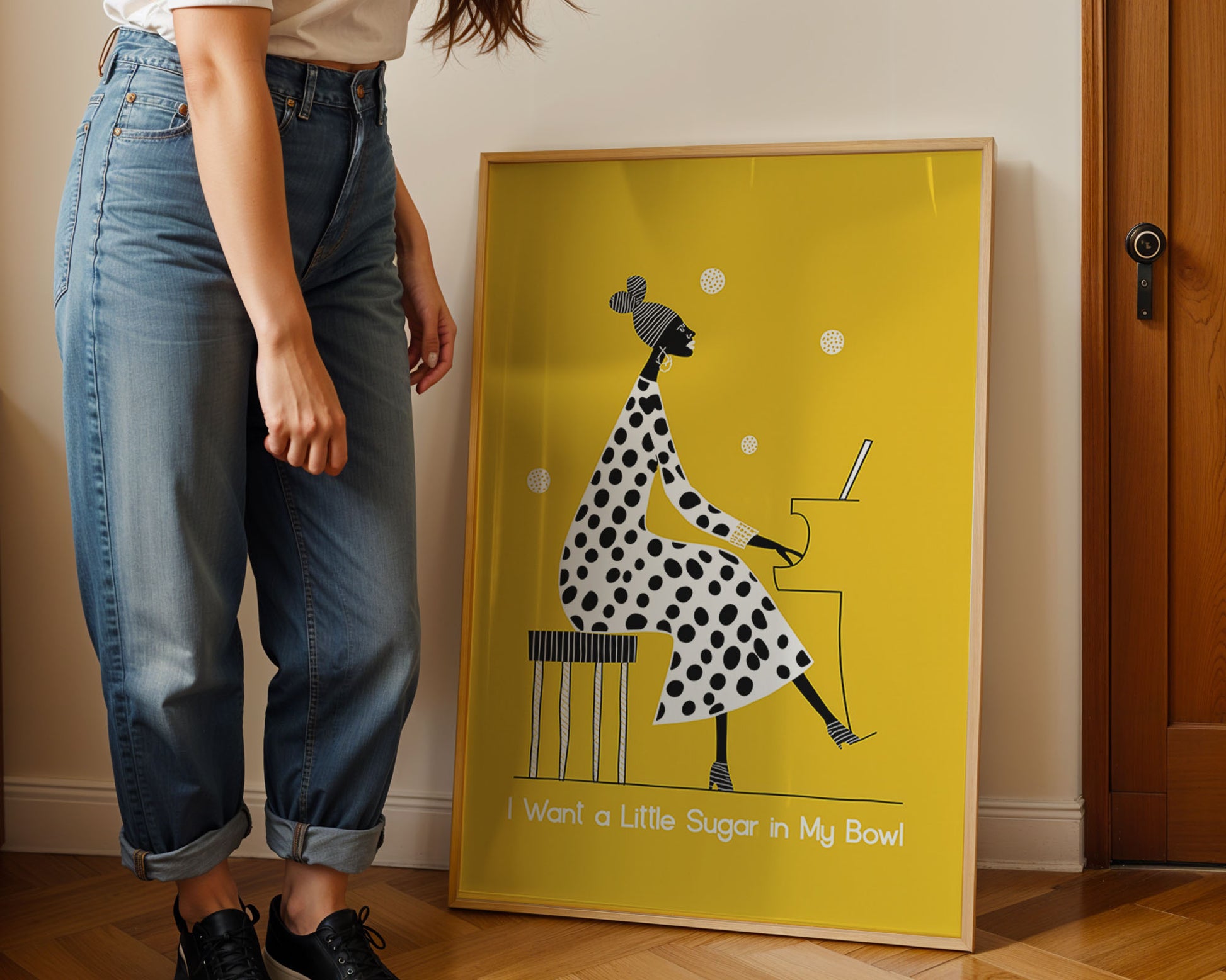 Person standing next to a framed artwork on a wall