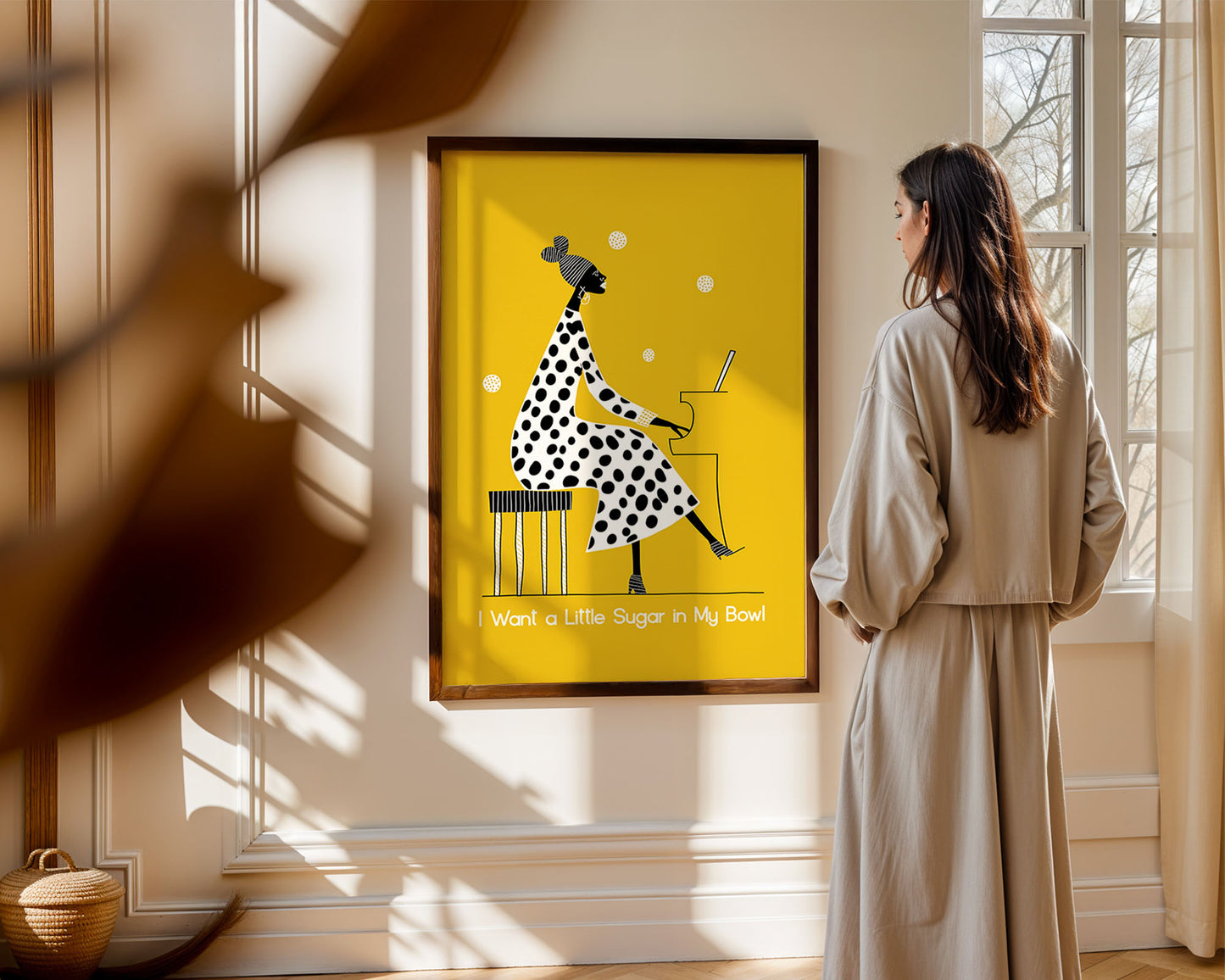 Woman standing in a room looking at a framed jazaz artwork on the wall.
