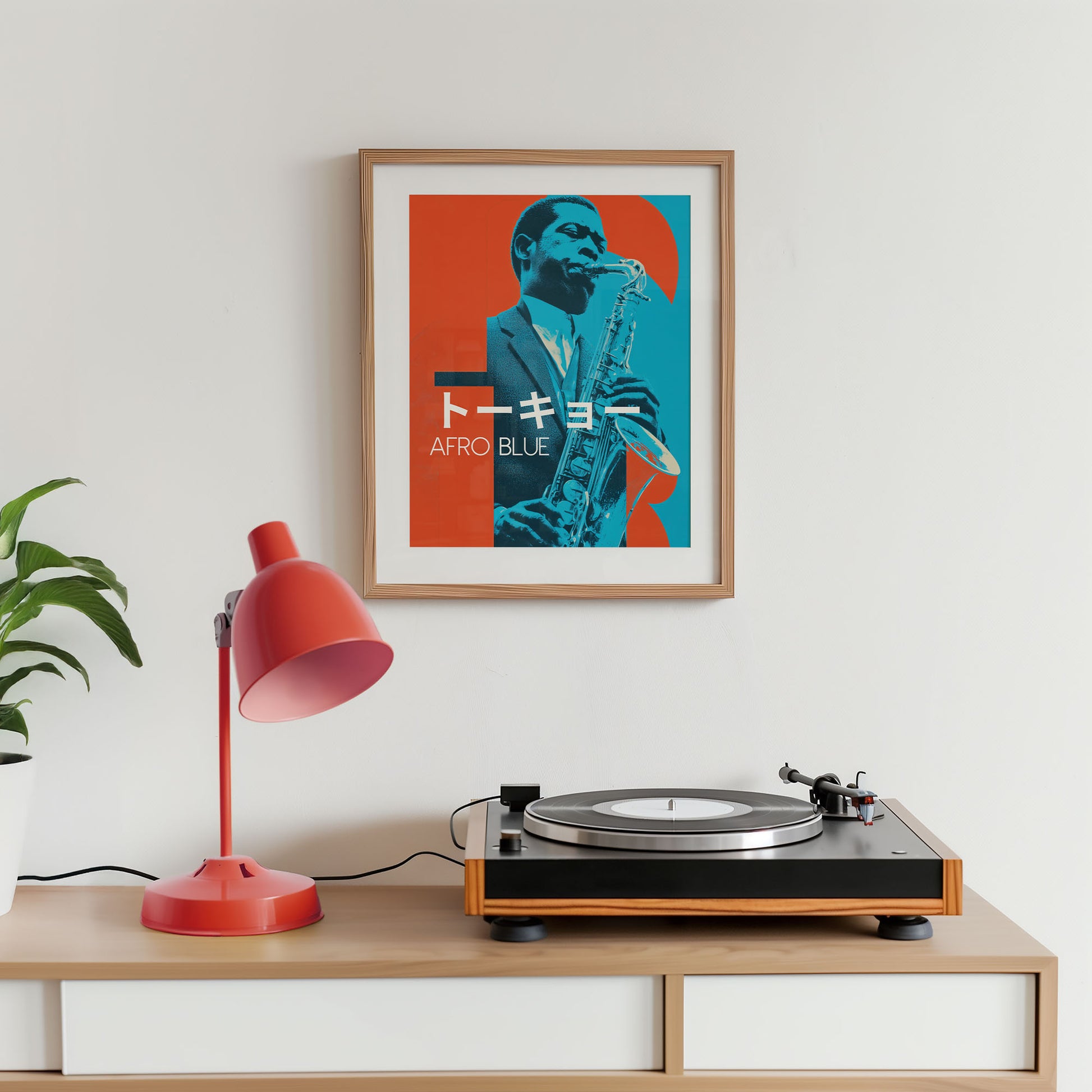 Turntable on a wooden shelf with a framed poster of a saxophonist and a red lamp.
