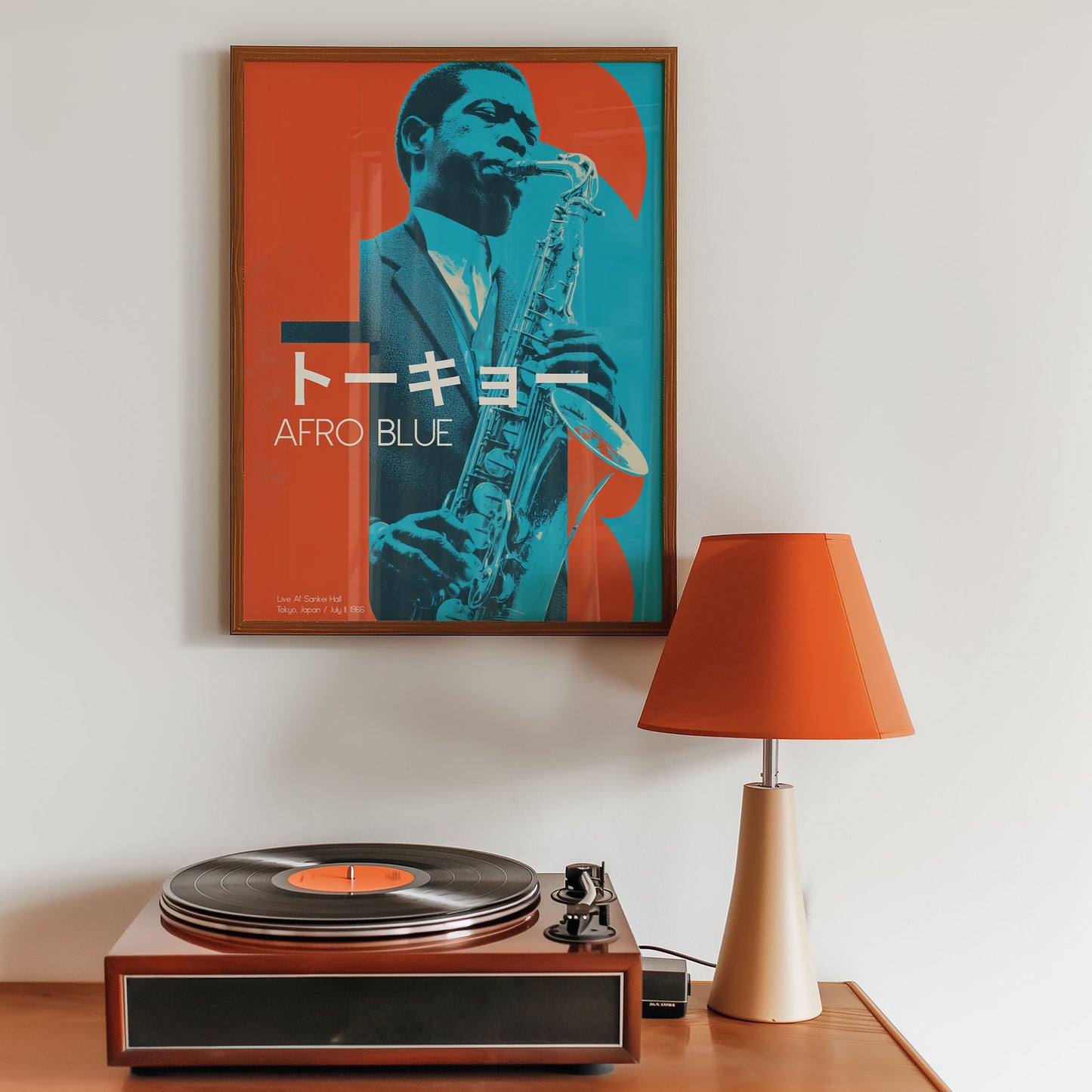 Framed poster of a saxophonist with 'Afro Blue' text, vinyl record player, and lamp on a wooden surface.