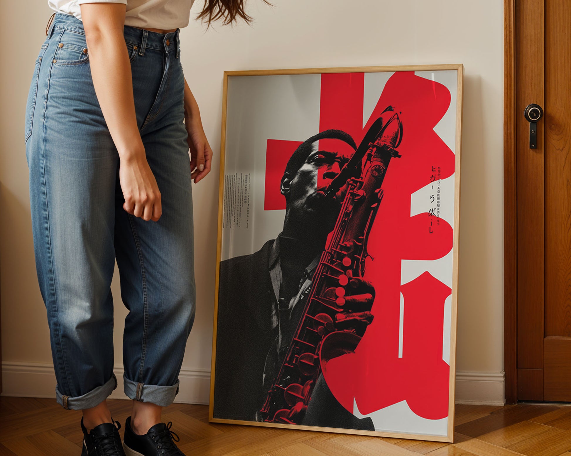 Person standing next to a framed poster of a musician playing a saxophone with red and black design.
