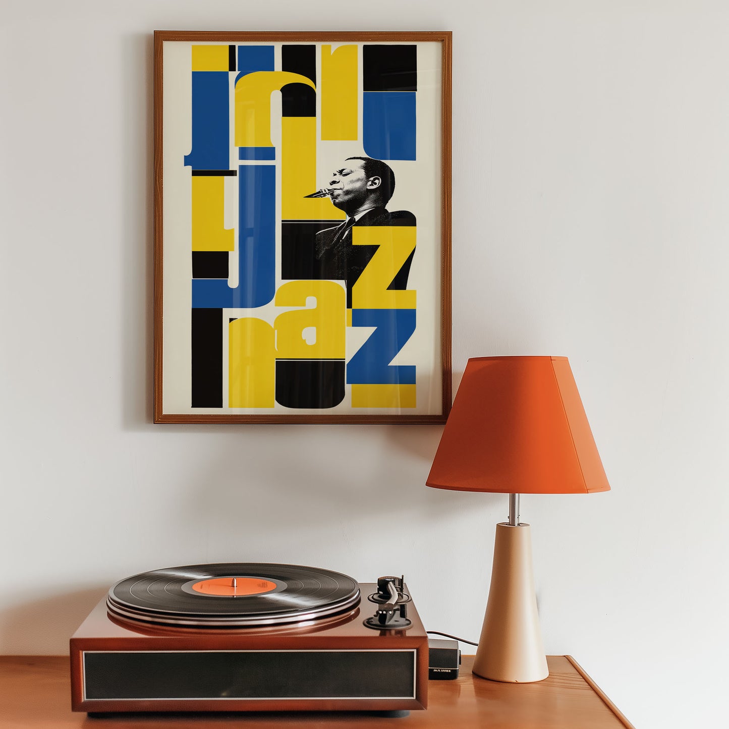 Framed jazz poster above a turntable with an orange lamp on a wooden surface.