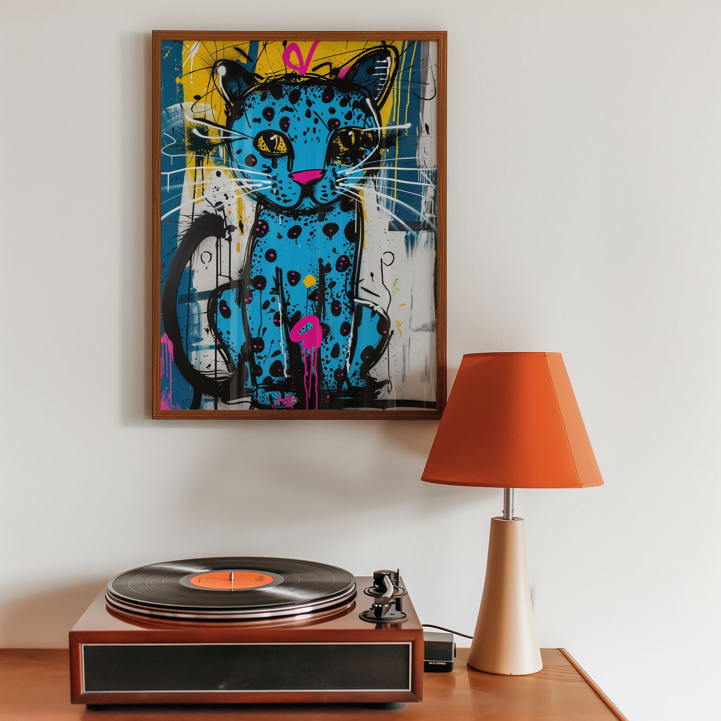 maximalist street art print colorful cat artwork above a turntable with an orange lamp on a wooden surface.
