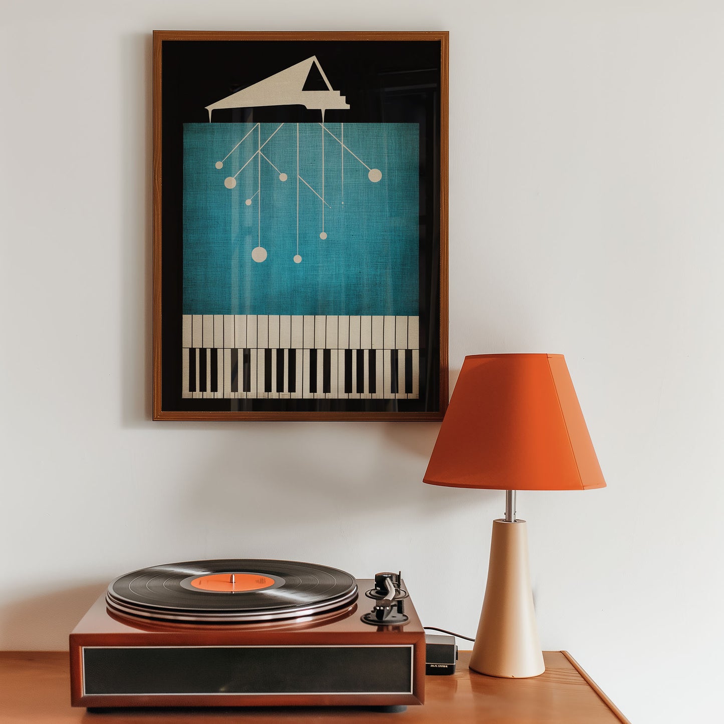 Framed artwork of a piano and keyboard on a wall above a record player with an orange lamp.