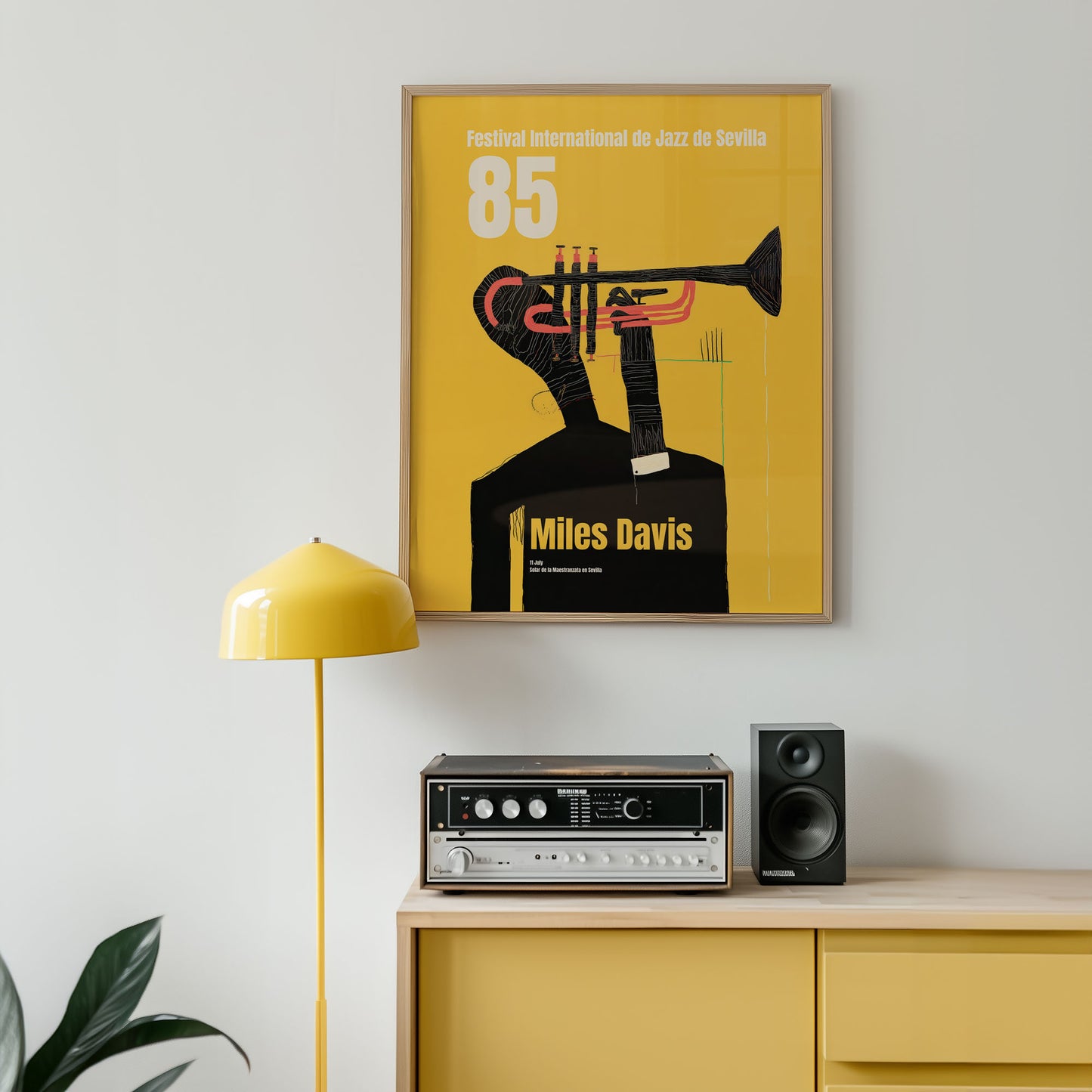 Framed Miles Davis poster on a wall above a yellow cabinet with audio equipment.
