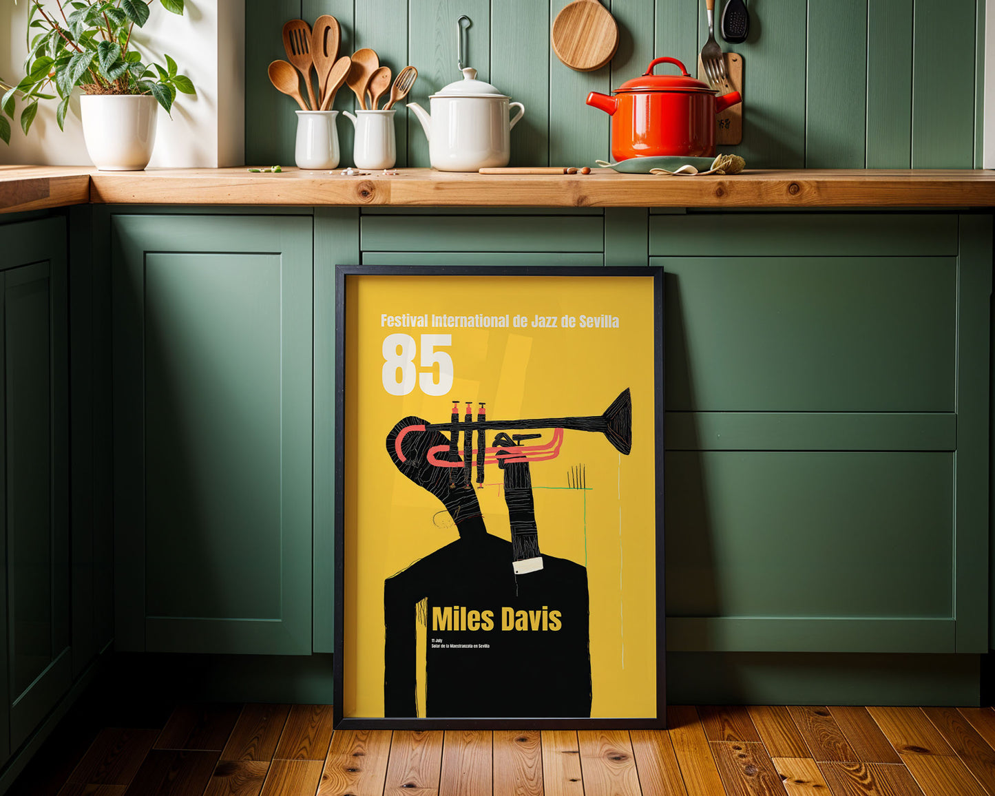 Framed Miles Davis poster on a kitchen wall with green cabinets and wooden countertops.