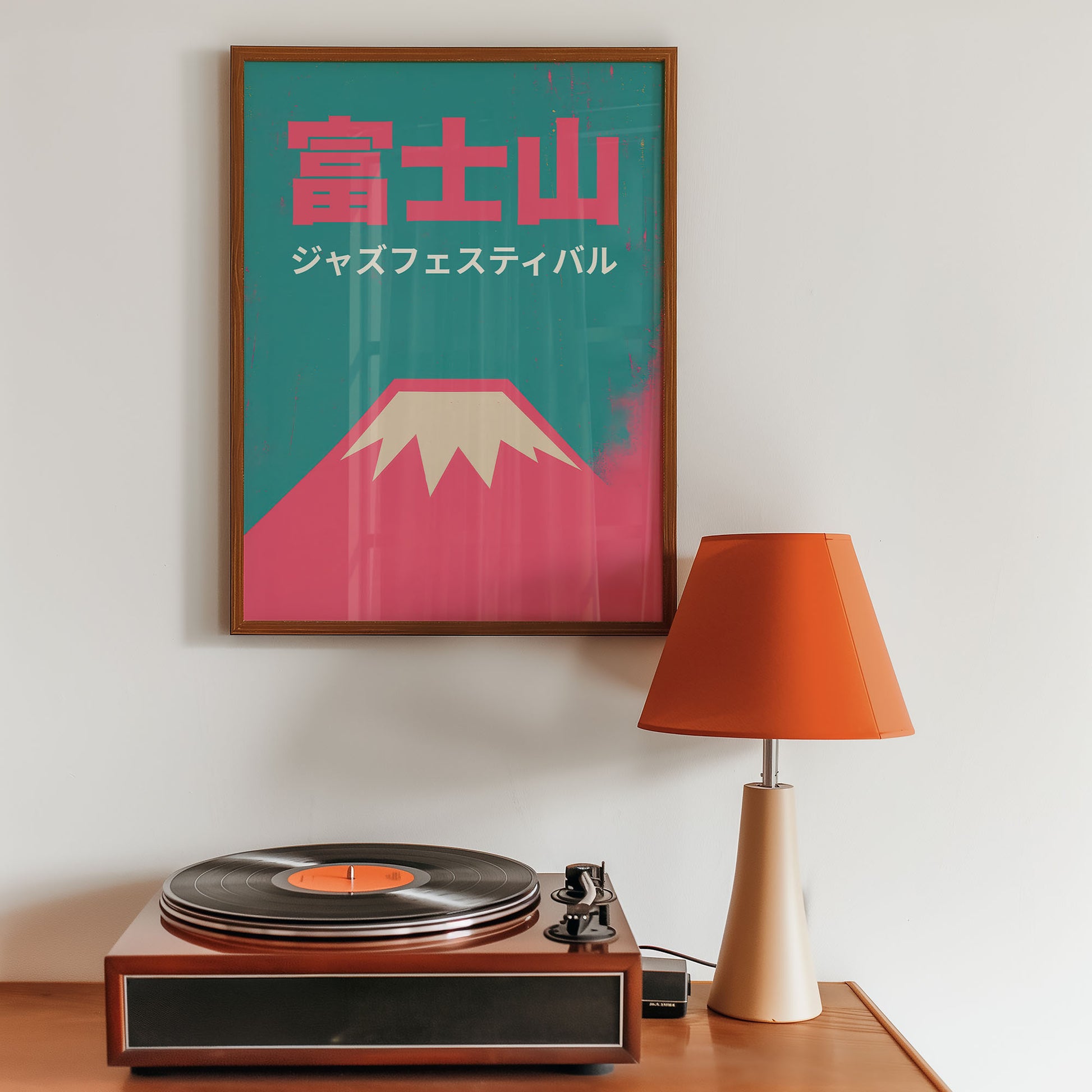 Framed poster of Mount Fuji with a turntable and lamp on a wooden surface.