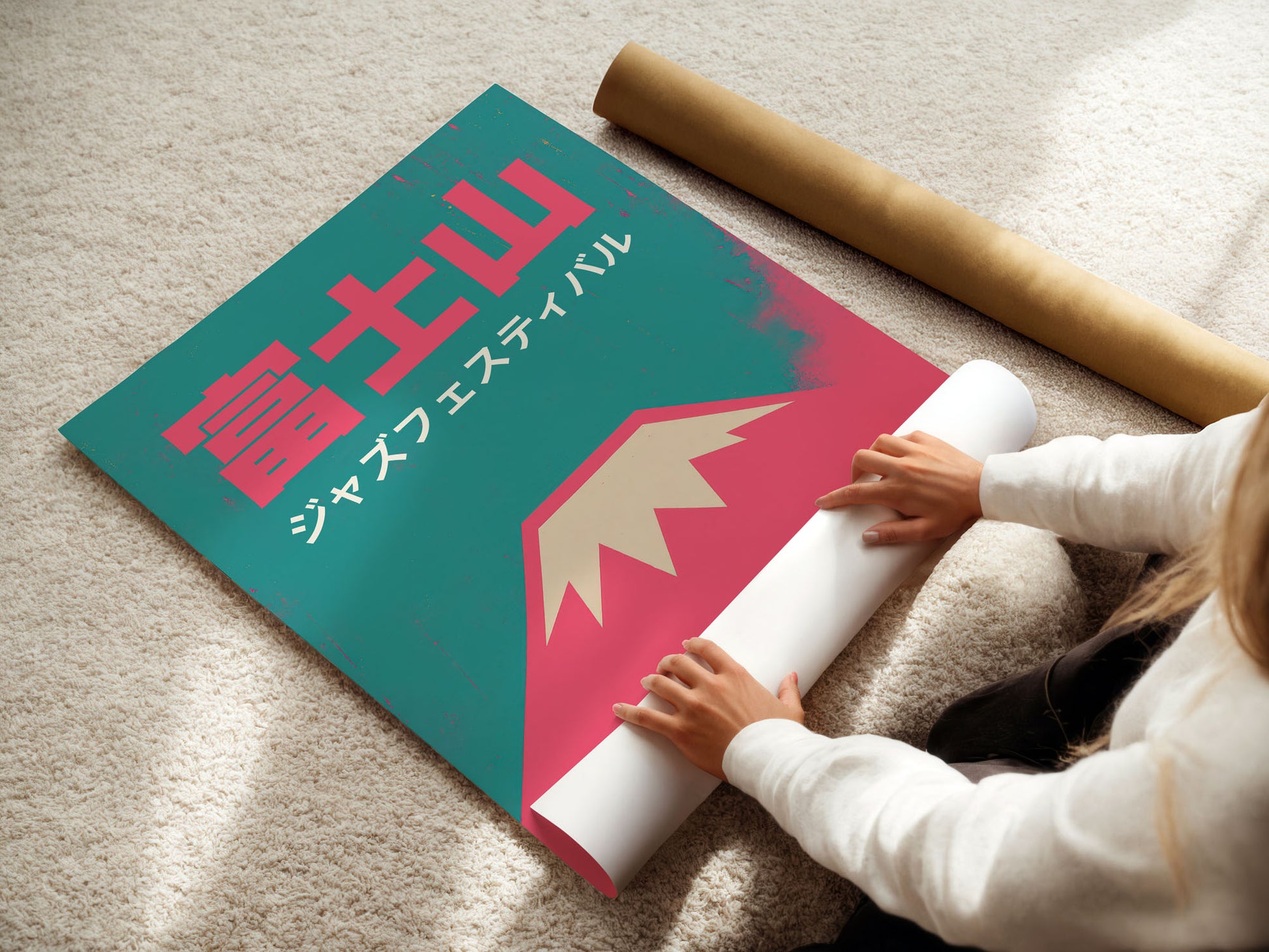 Person unrolling a large poster with Japanese text on a light-colored floor.