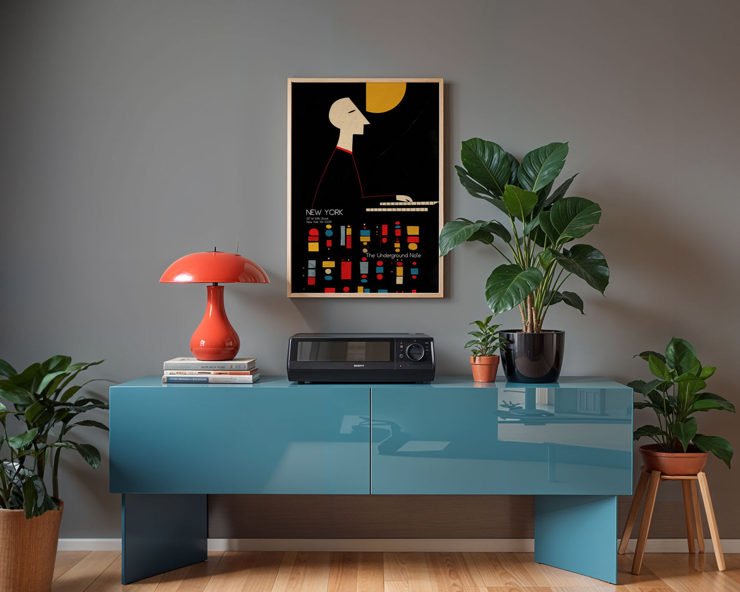 Modern interior with a blue console table, red lamp, and framed artwork on a gray wall.