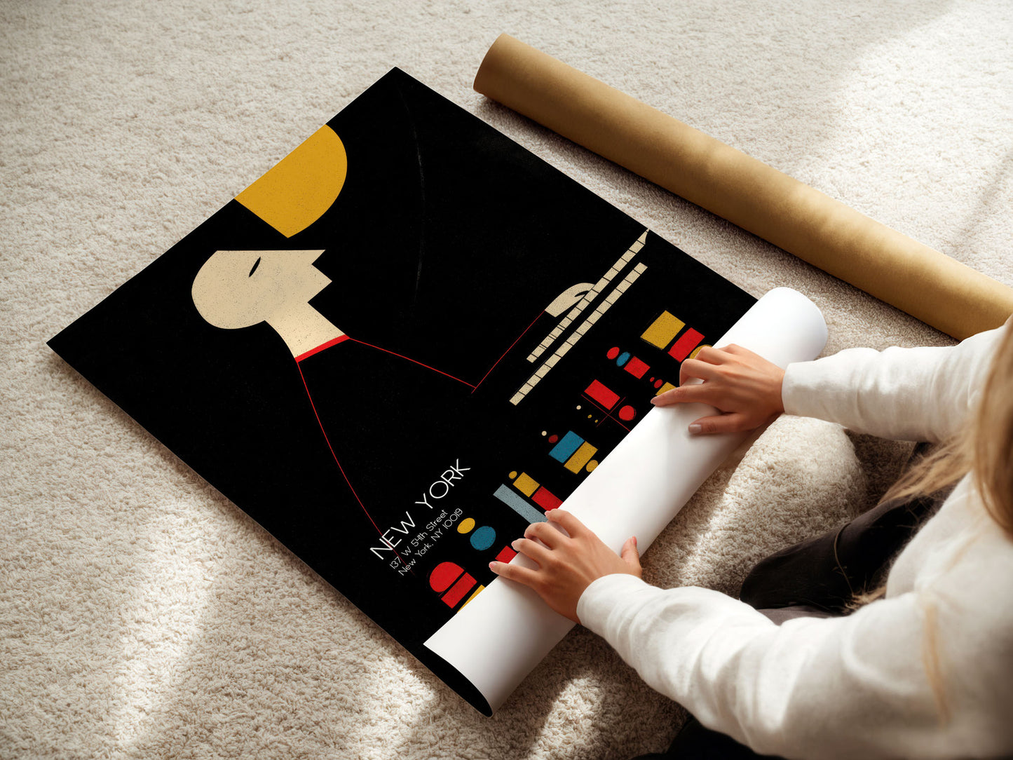 Person unrolling a poster of a New York cityscape on a carpeted floor.