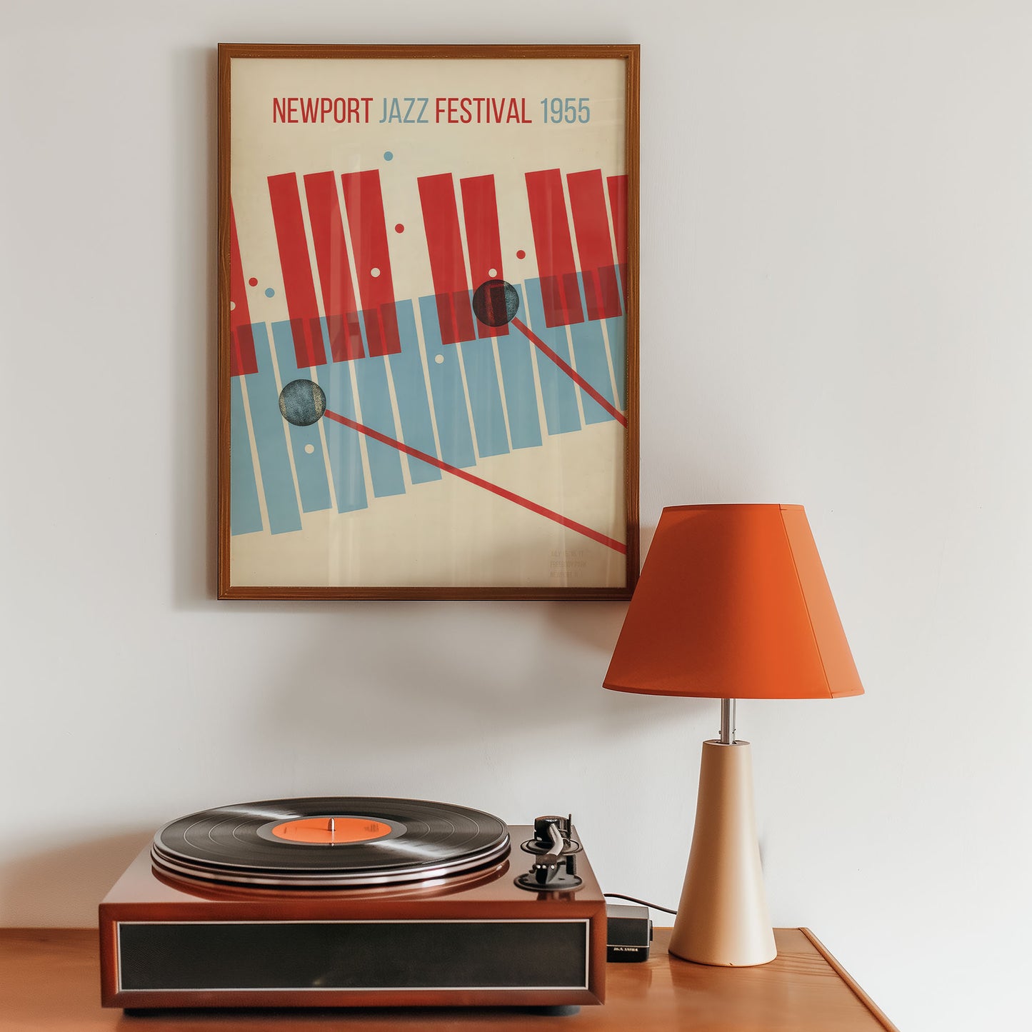 Framed poster of the Newport Jazz Festival 1955 above a vintage turntable with an orange lamp.