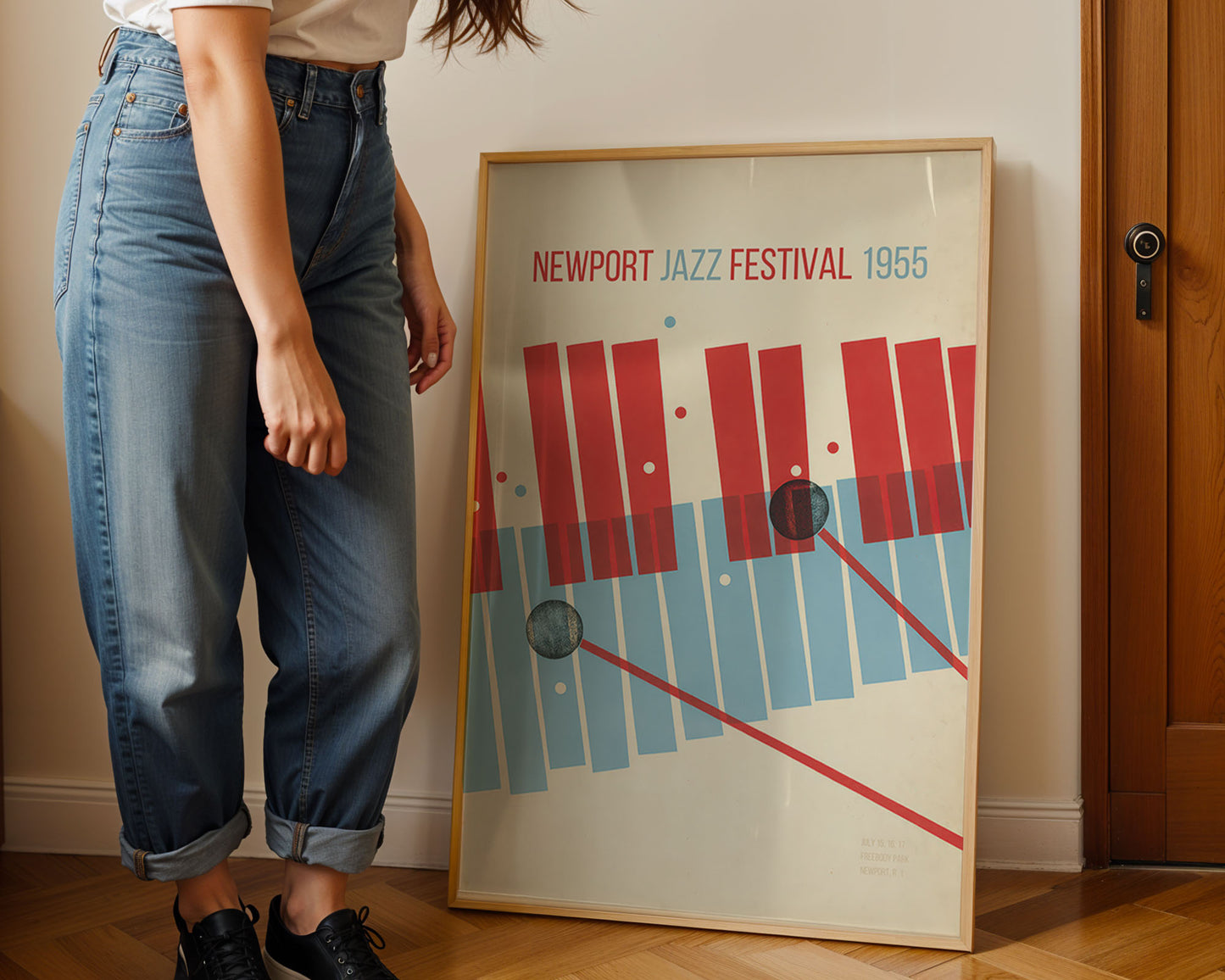 Person standing next to a framed poster of the Newport Jazz Festival 1956.