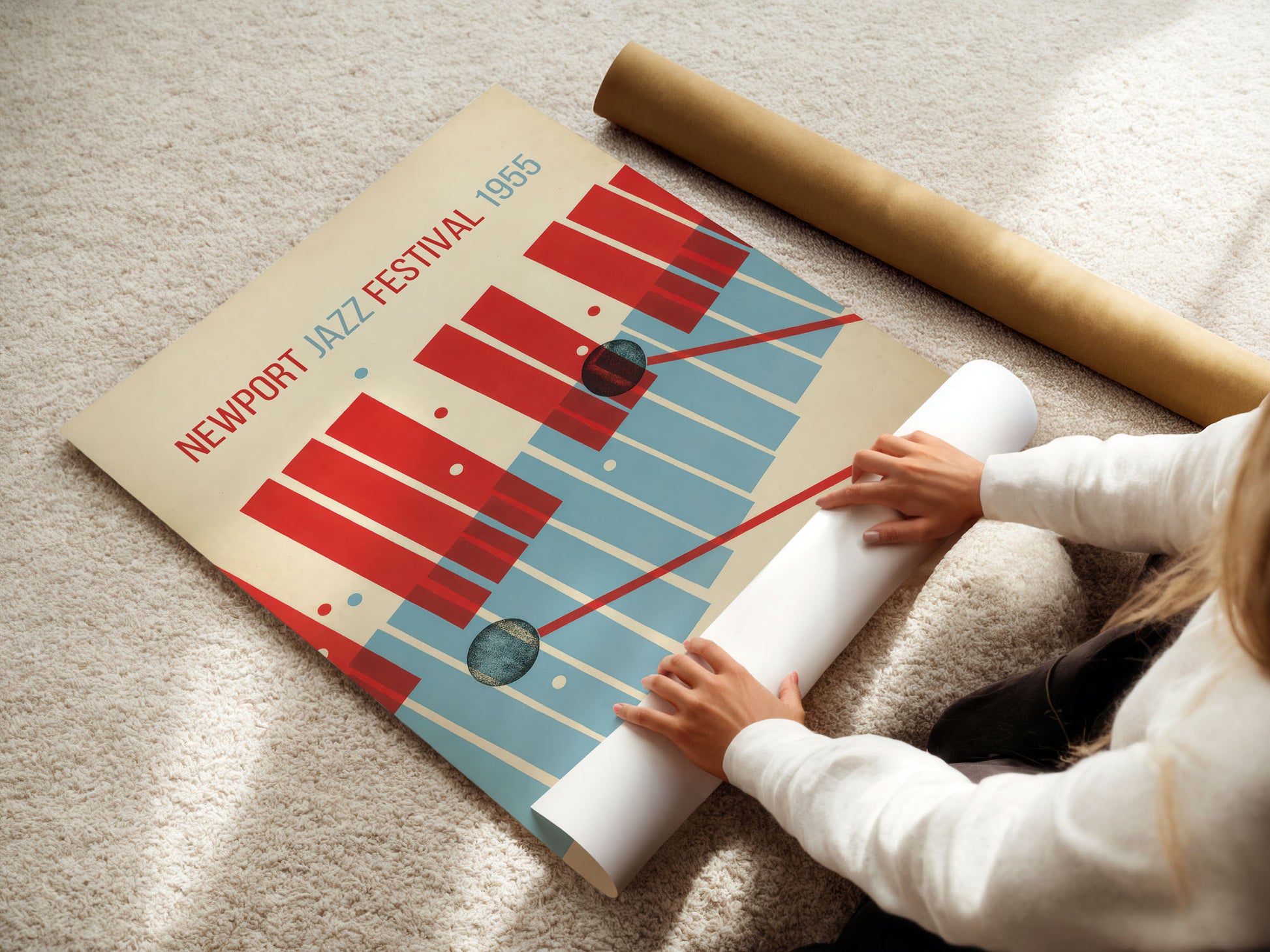 Person unrolling a poster of the Newport Jazz Festival 1985 on a carpeted floor.