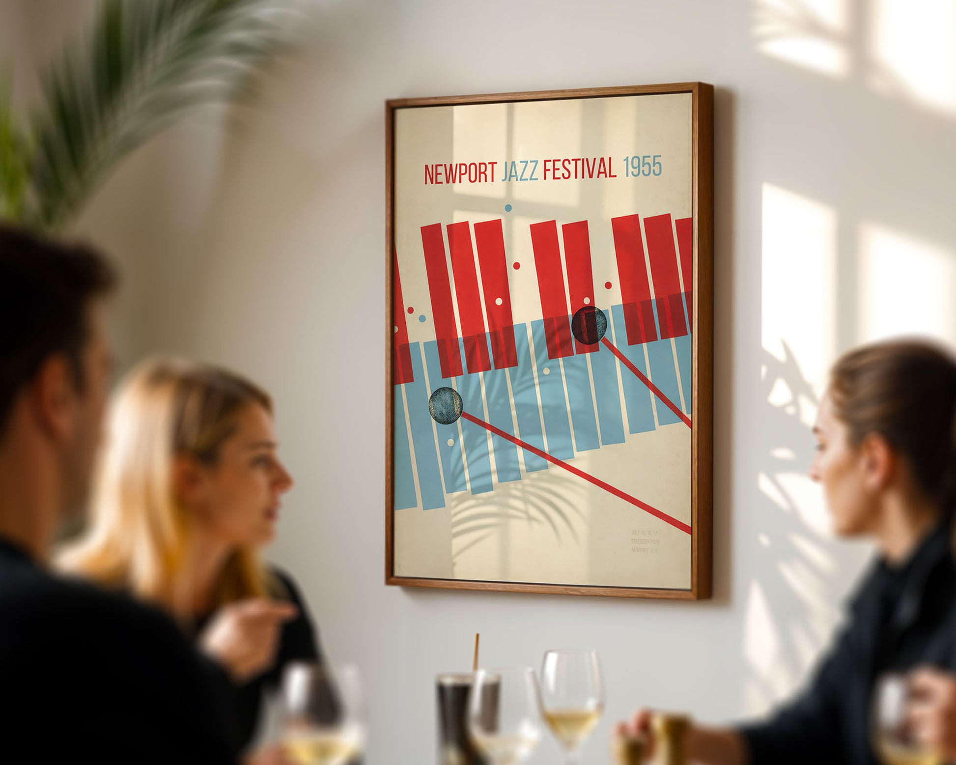 Framed poster of the Newport Jazz Festival 1965 on a wall with people in the foreground.