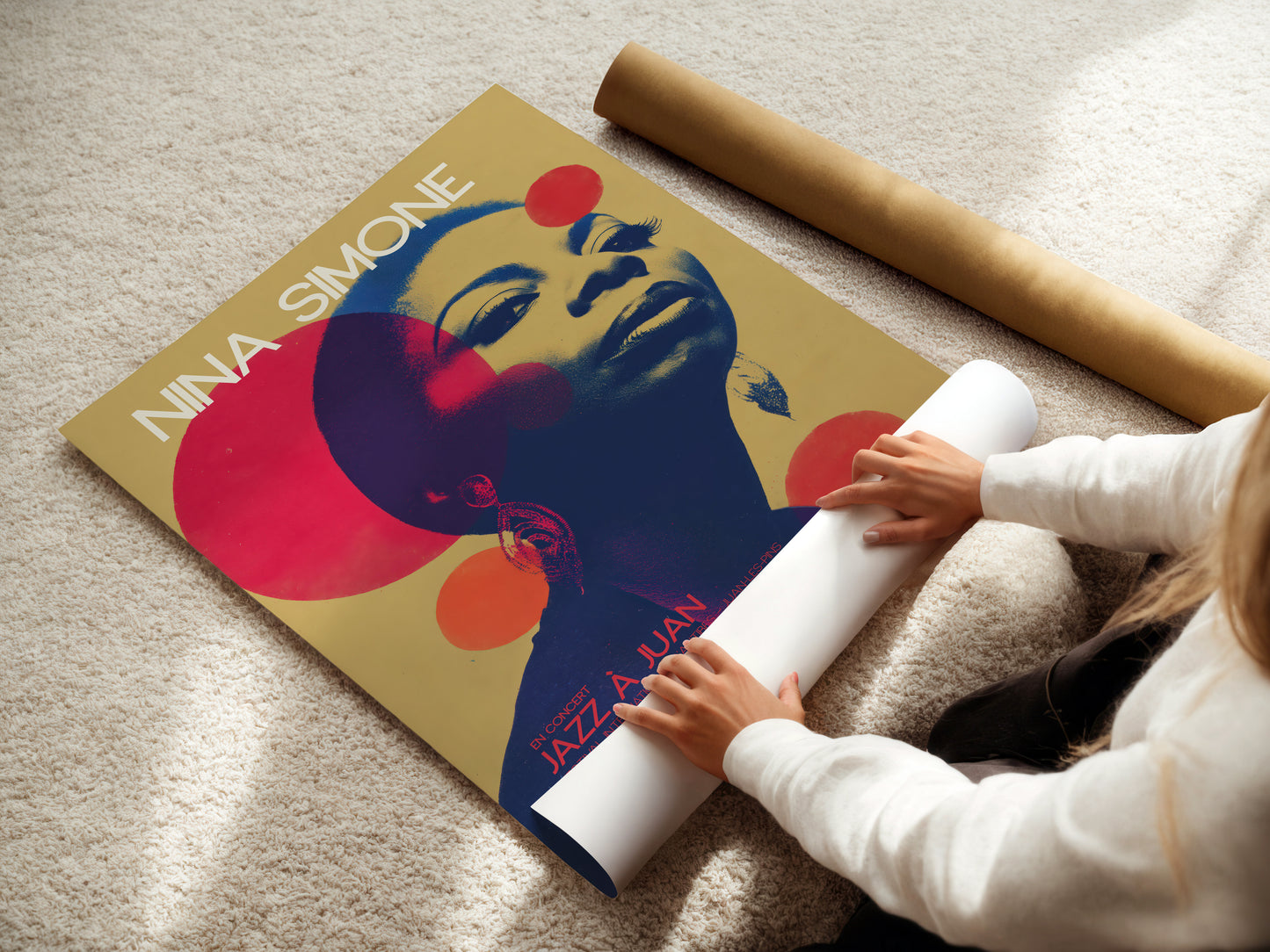 Person unrolling a poster of Nina Simone on a carpeted floor