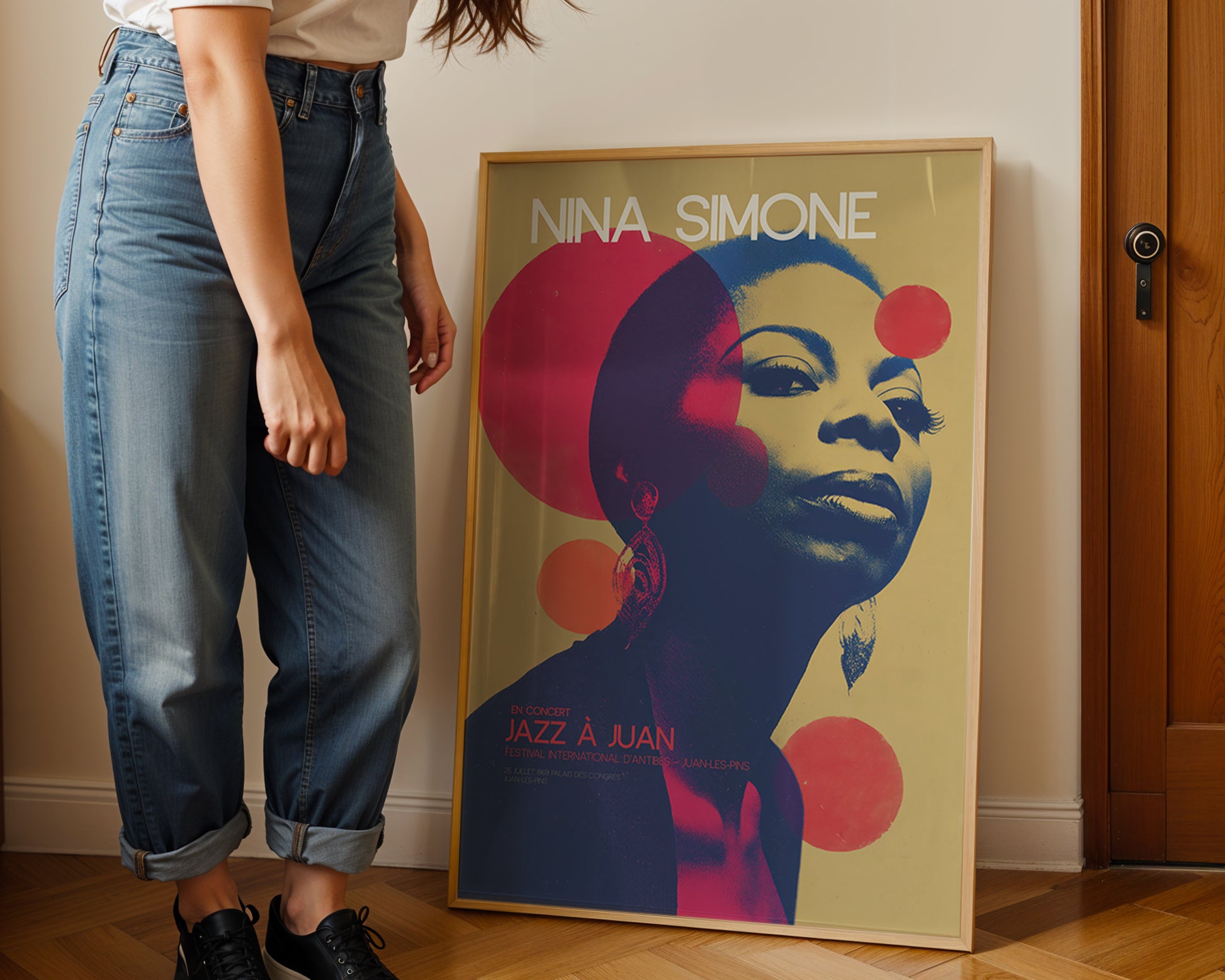 Person standing next to a colorful poster of Nina Simone on a wall.