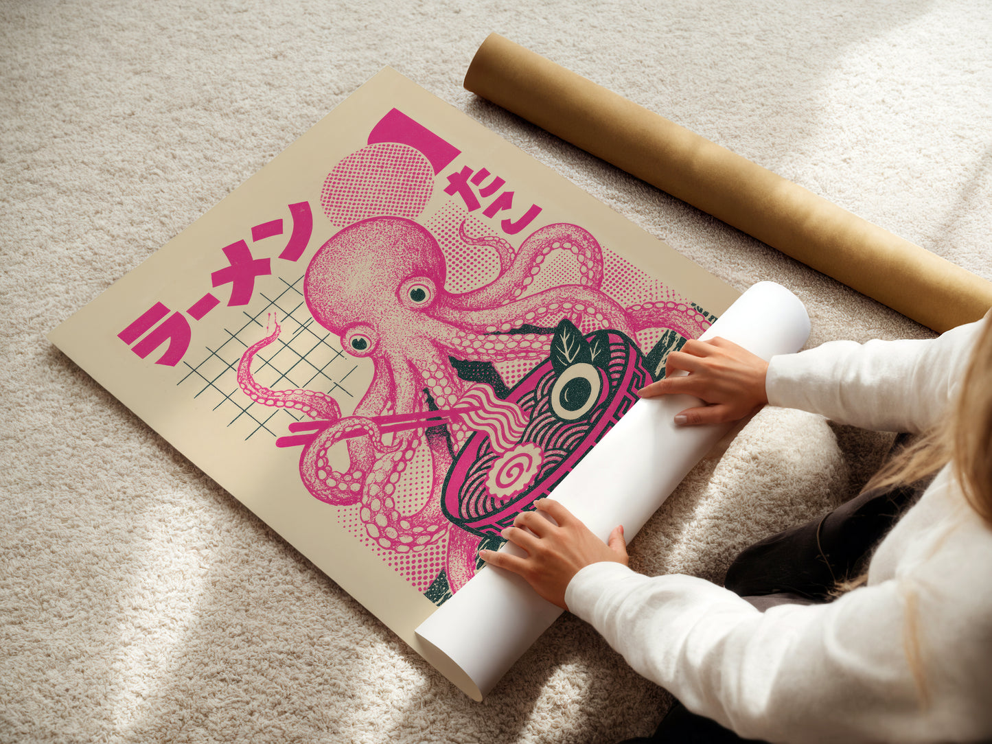 Person unrolling a large pink octopus poster with Japanese text on a light-colored floor.