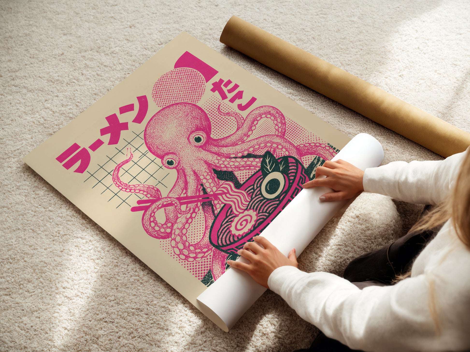 Person unrolling a large pink octopus poster with Japanese text on a light-colored floor.