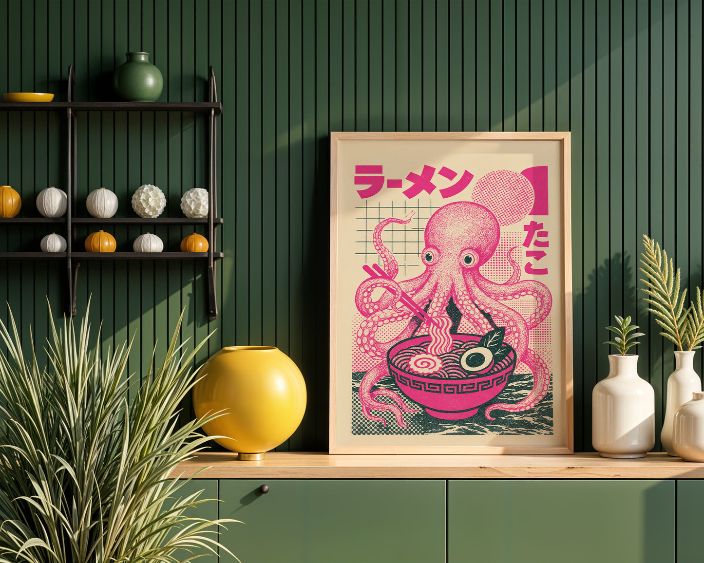 Framed artwork of a pink octopus with a bowl of ramen on a wooden shelf against a modern kitchen interior.