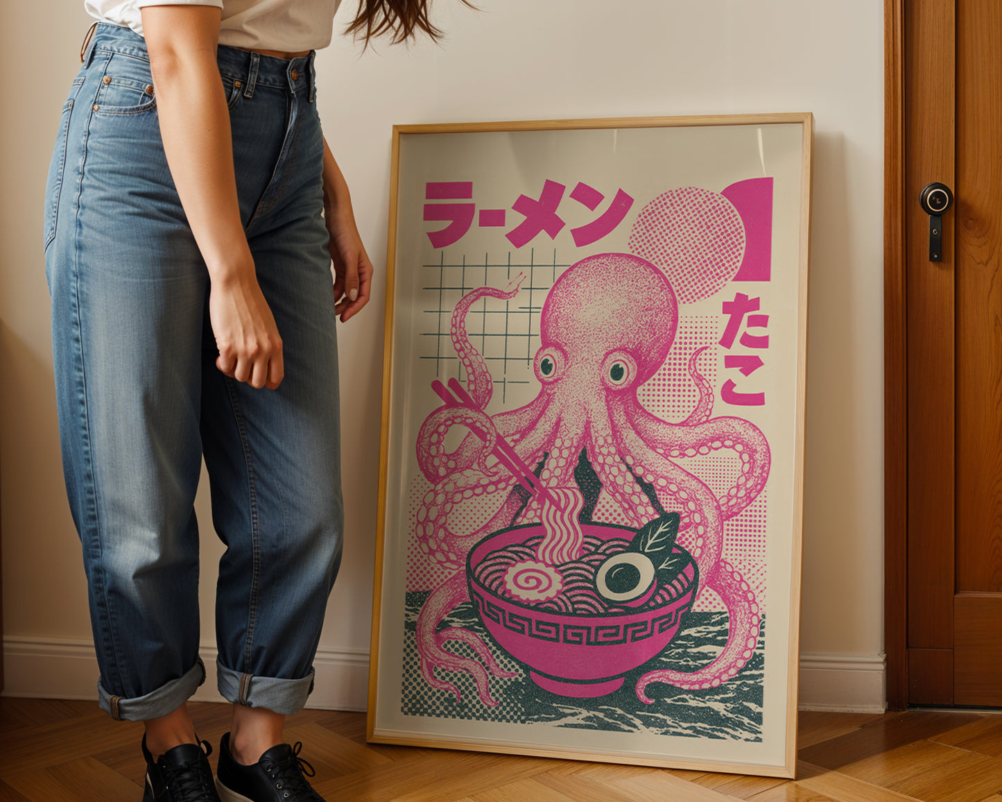 Person standing next to a framed artwork of an octopus with ramen noodles.