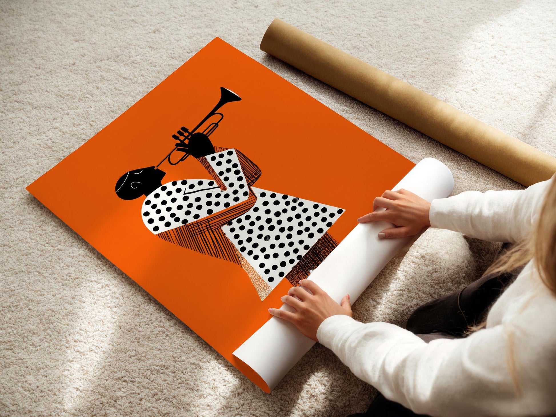 Person unrolling a poster with a design of a polka-dotted dress and a trumpet on an orange background.
