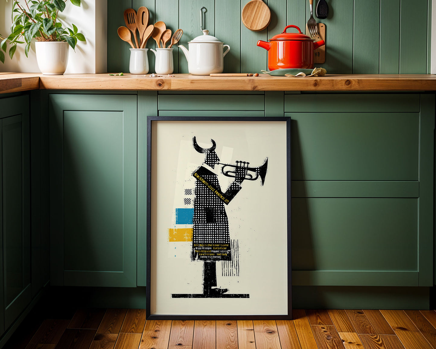 Framed artwork of a person playing a trumpet in a kitchen setting with green cabinets and wooden countertops.