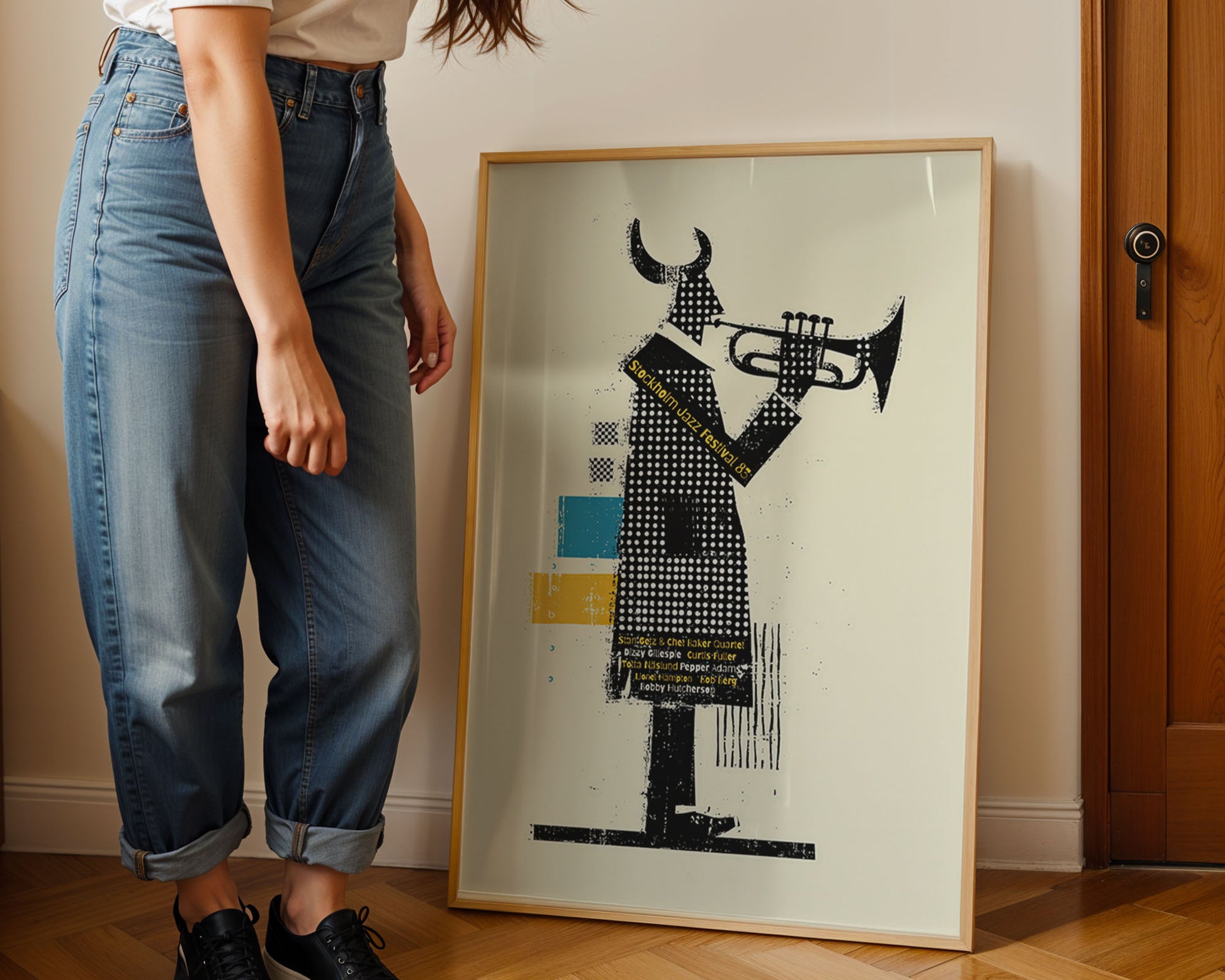 Person standing next to a framed artwork of a person playing a trumpet on a wall.