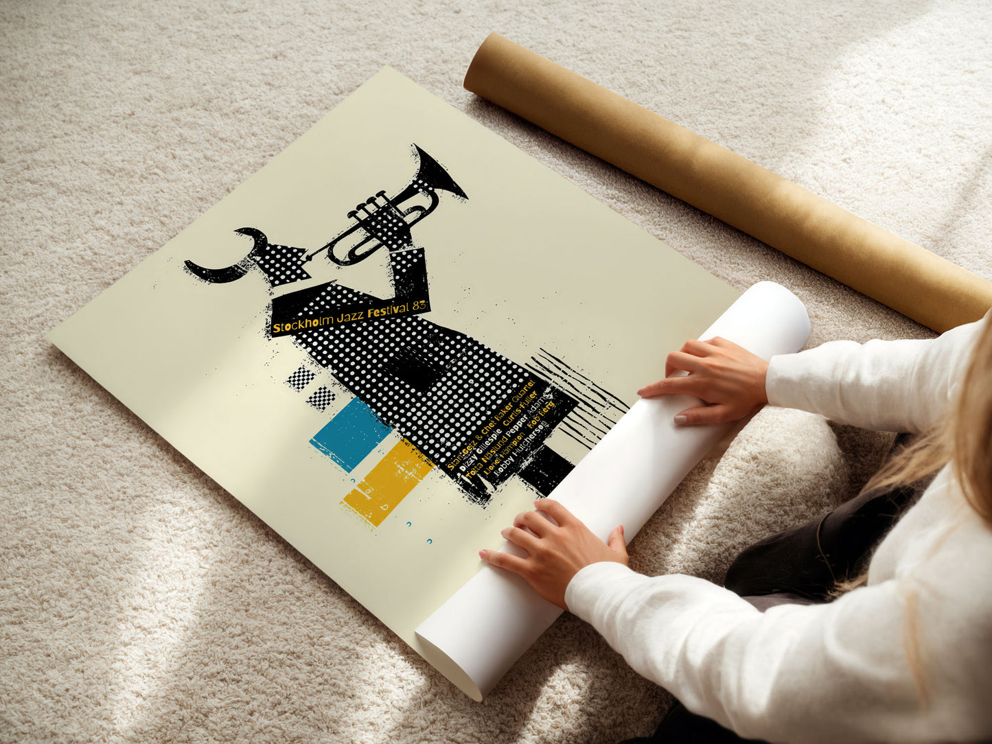 Person unrolling a large poster with artistic design on a light-colored floor.