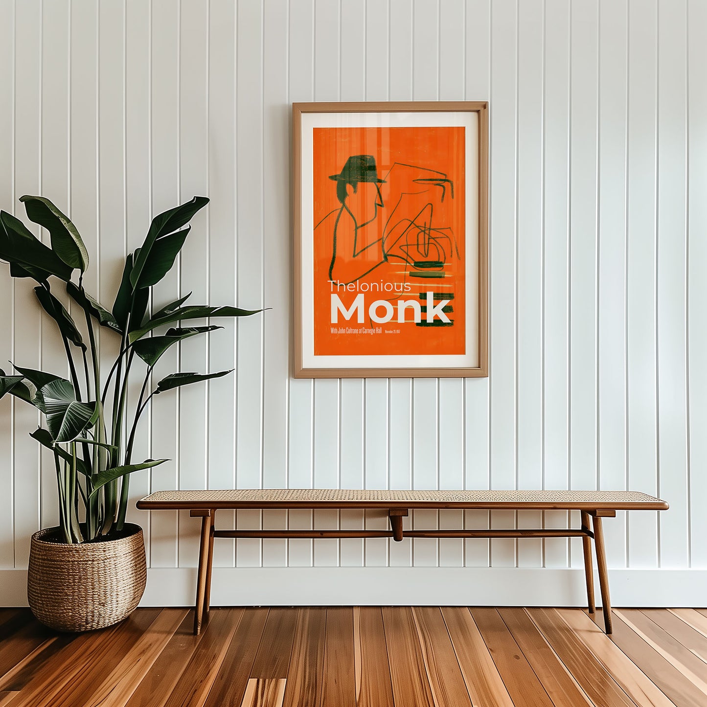 Framed poster of Thelonious Monk on a wall with a wooden bench and plant below.