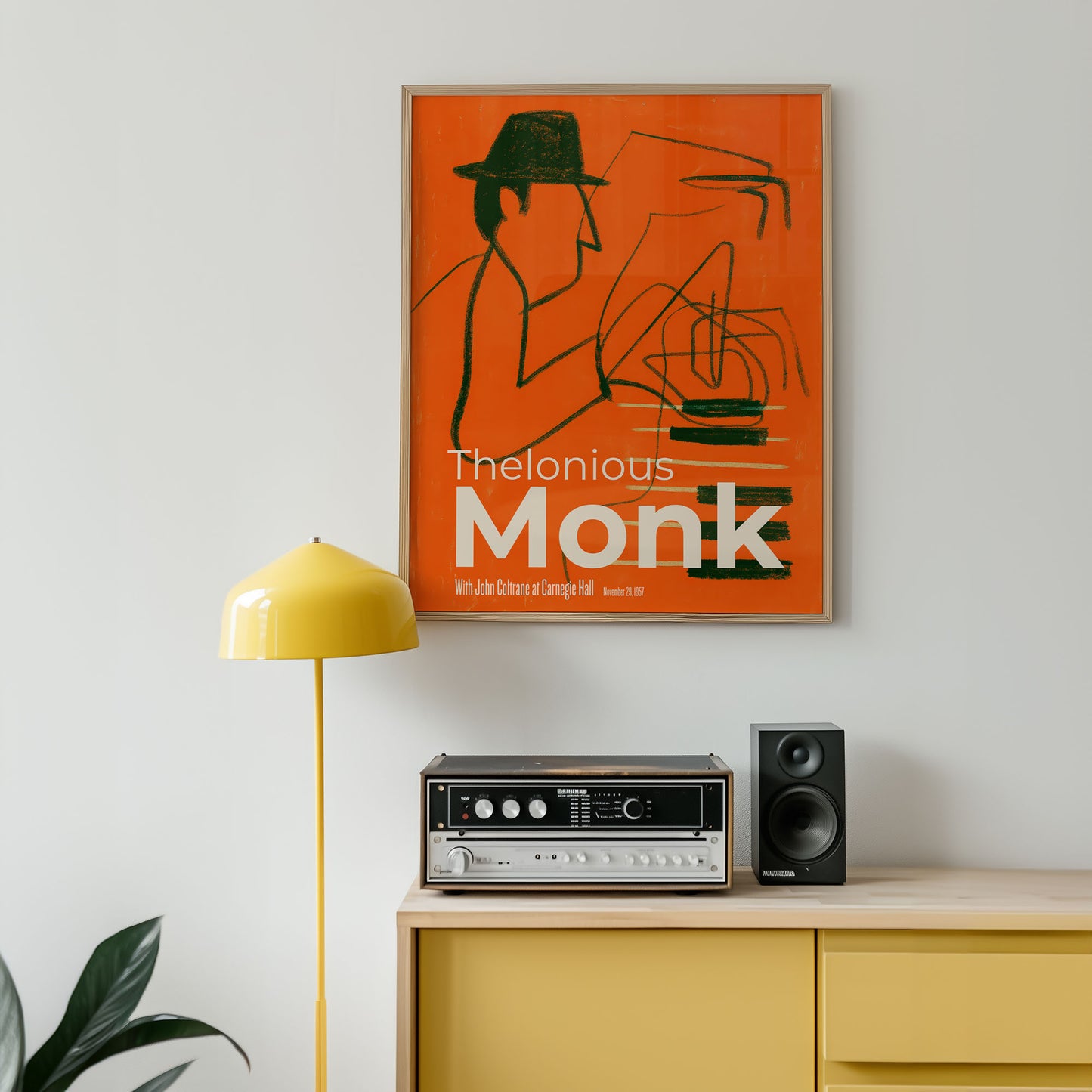 Poster of Thelonious Monk on a wall above a yellow cabinet with audio equipment.