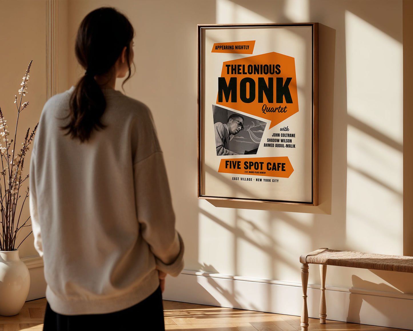 Person looking at a framed album cover of Thelonious Monk in a room with sunlight streaming in.