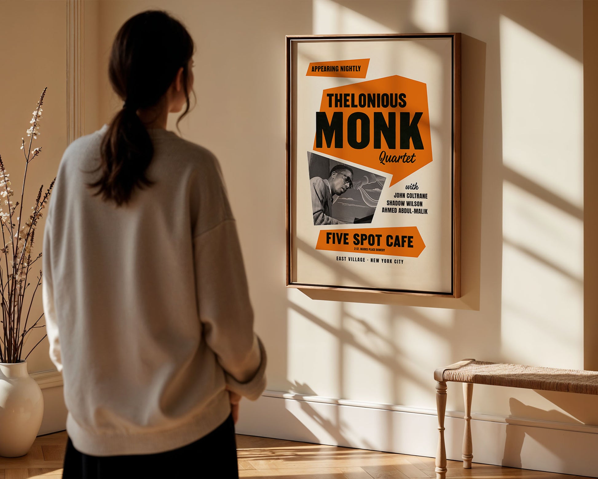 Person looking at a framed album cover of Thelonious Monk in a room with sunlight streaming in.