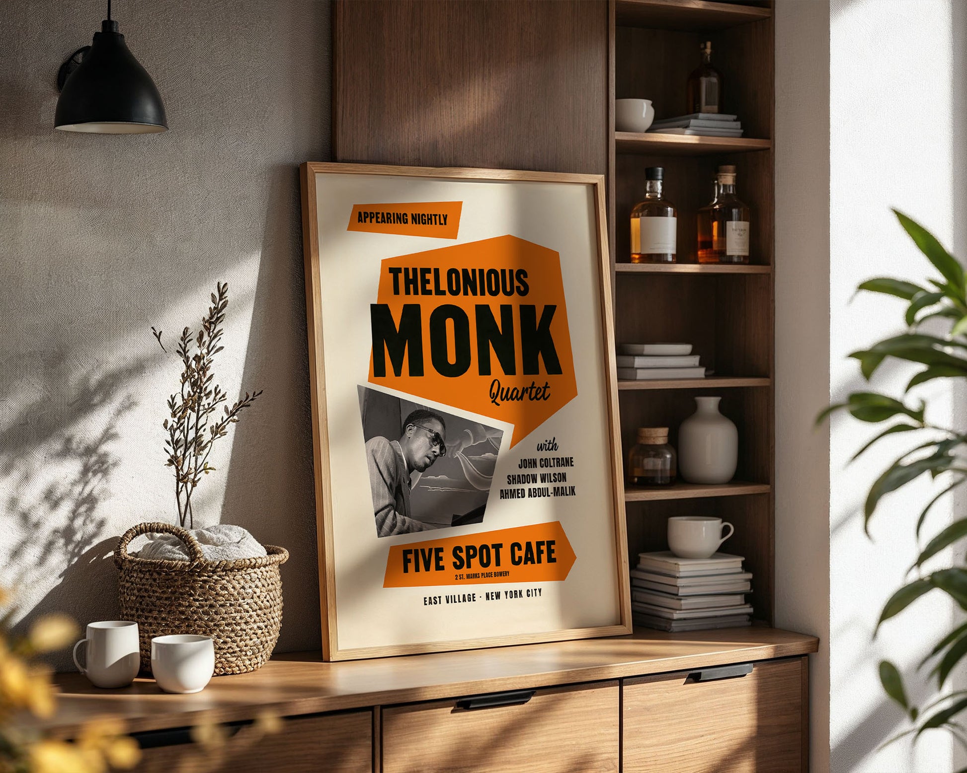Framed poster of Thelonious Monk Quartet on a wooden shelf with decor items.