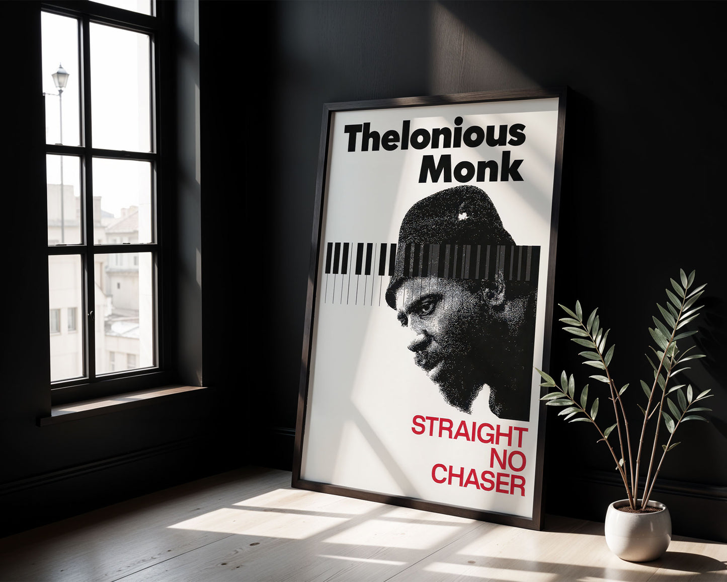 Framed poster of Thelonious Monk with a piano keyboard design in a room with a window and plant.