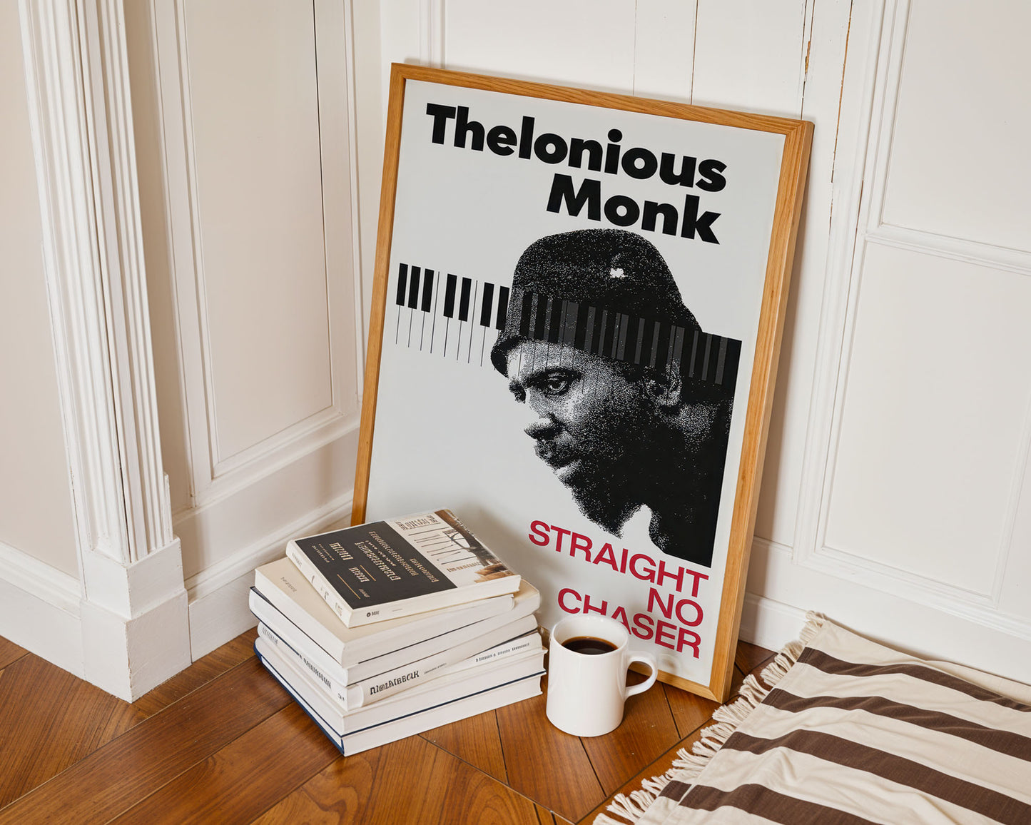 Framed poster of Thelonious Monk on a wall with books and a mug below.