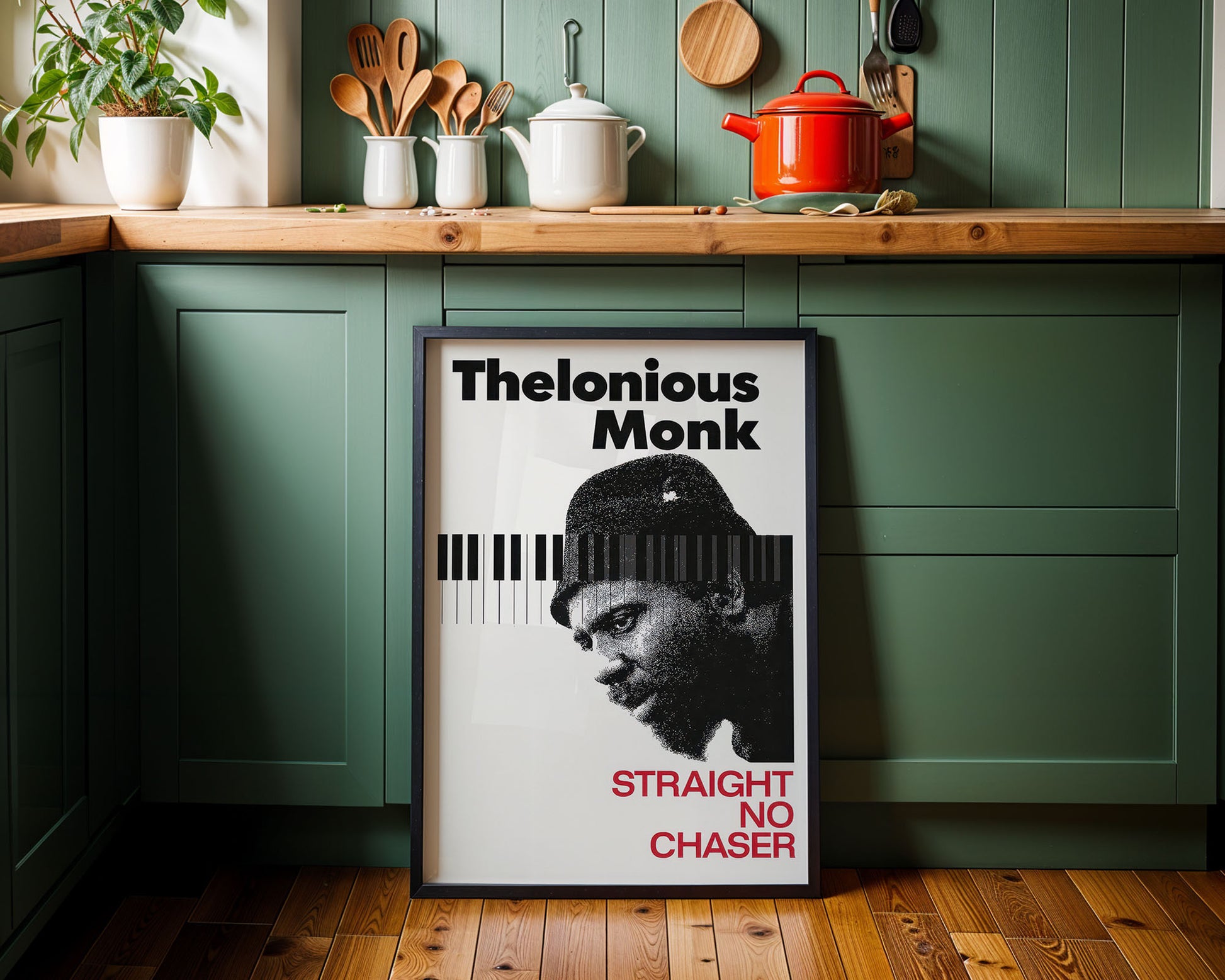 Framed poster of Thelonious Monk in a kitchen setting with green cabinets and wooden countertops.