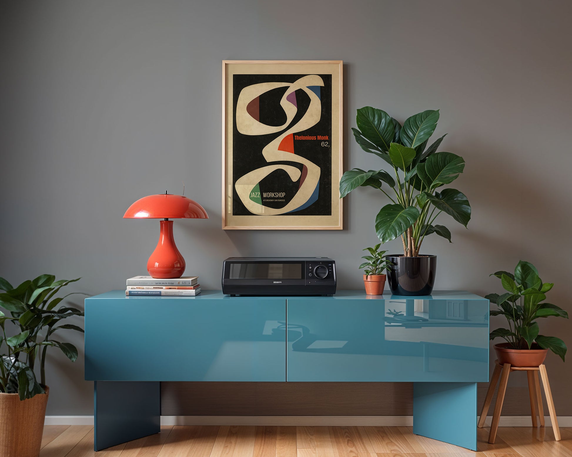 Modern interior with a blue console table, red lamp, and plants against a gray wall.