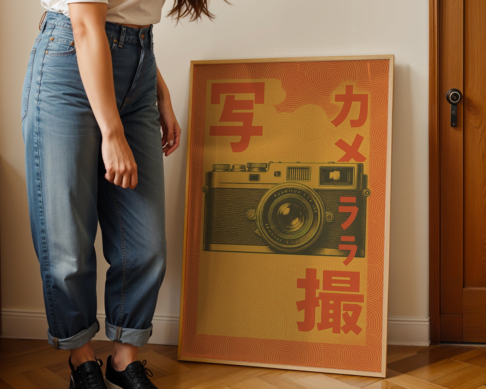 Person standing next to a framed poster of a camera with Japanese text on a wall.