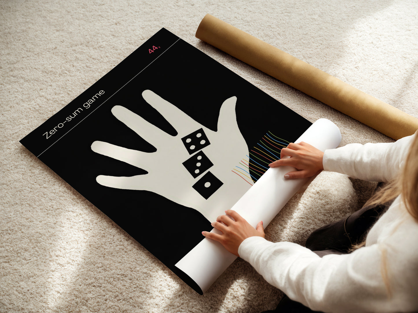 Person unrolling a white paper with a hand design on a black mat with game theory symbols.